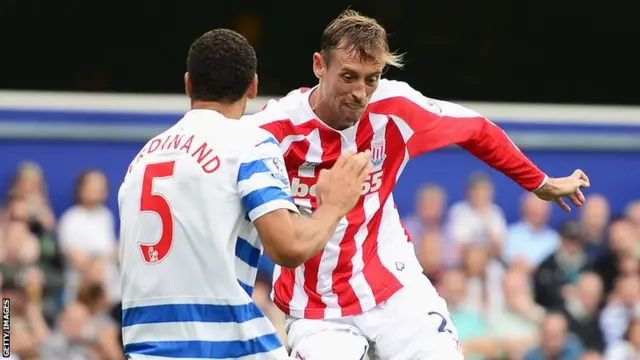 Peter Crouch of Stoke takes on Rio Ferdinand