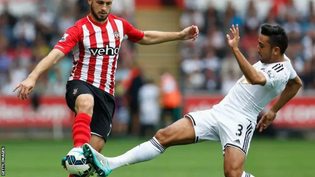 Southampton's Shane Long and Swansea's Neil Taylor go for the ball