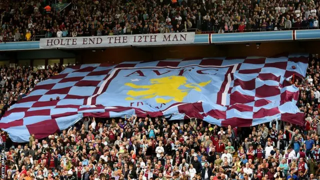 Aston Villa fans hold up a flag for the Arsenal match