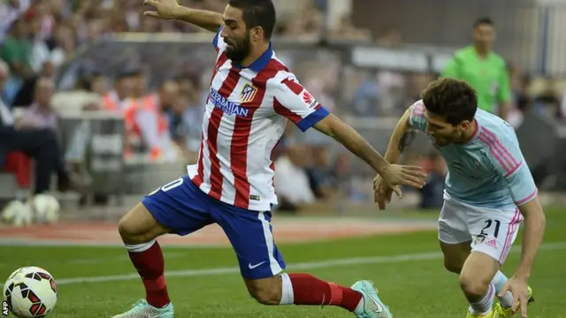 Atletico Madrid's Arda Turan and Carles Planas of Celta Vigo vie for the ball