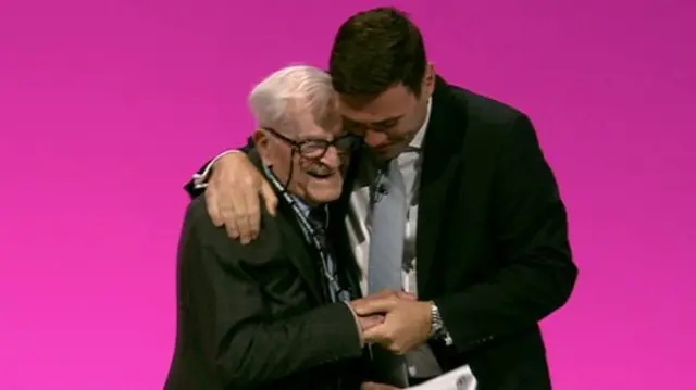 Shadow health secretary Andy Burnham embraces Harry Smith after his captivating speech