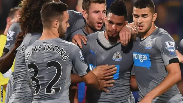 Newcastle's Emmanuele Riviere is mobbed by team-mates after his goal