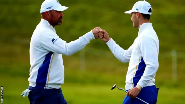 Thomas Bjorn (L) of Europe celebrates his birdie with Martin Kaymer of Europ