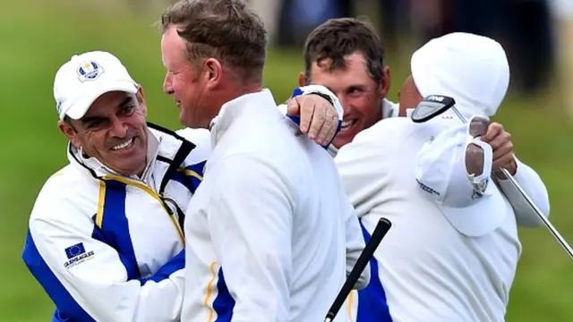 Team Europe's Jamie Donaldson of Wales (2nd L) and Lee Westwood of England (2nd R) are congratulated by Captain of Team Europe Paul McGinley