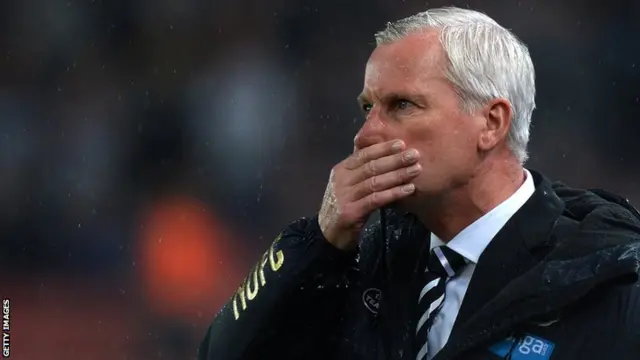 Newcastle United manager Alan Pardew wipes the rain off his face