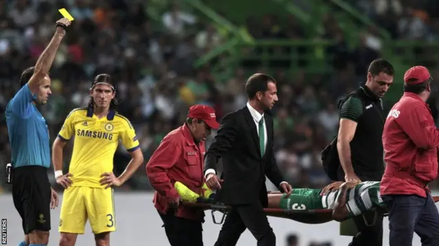 Sporting Lisbon's Mauricio gets a yellow card as he is stretchered off