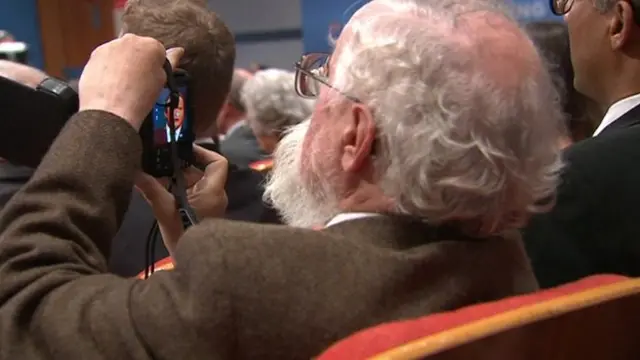 Audience member taking a picture of David Cameron