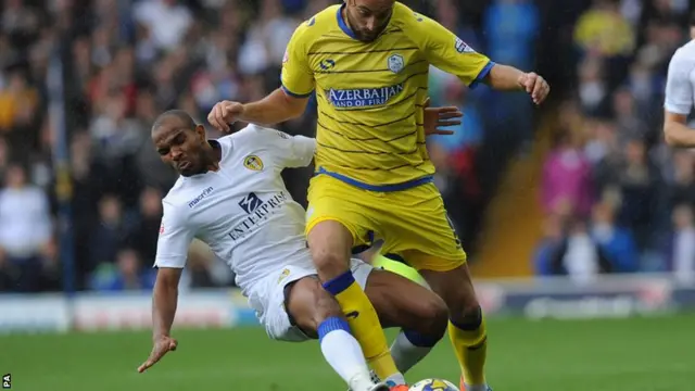 Sheffield Wednesday's Atdhe Nuhiu is tackled by Leeds' Rodolph Austin