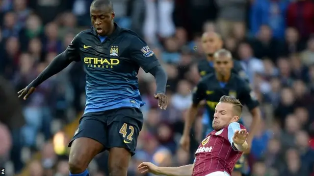 Manchester City's Yaya Toure beats Aston Villa midfielder Tom Cleverley to the ball