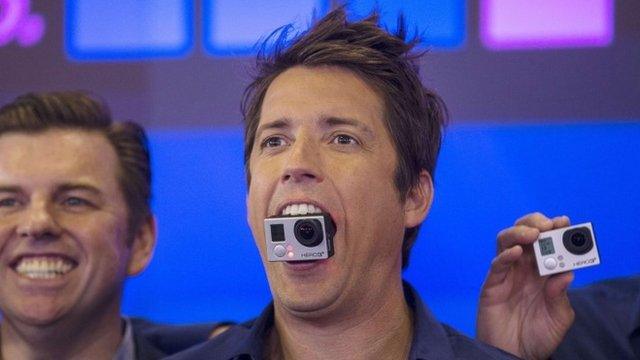 GoPro Inc"s founder and CEO Woodman holds a GoPro camera at the Nasdaq Market