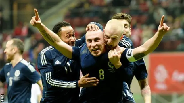 Scott Brown is congratulated by Scotland team-mates after scoring the winner against Poland in March