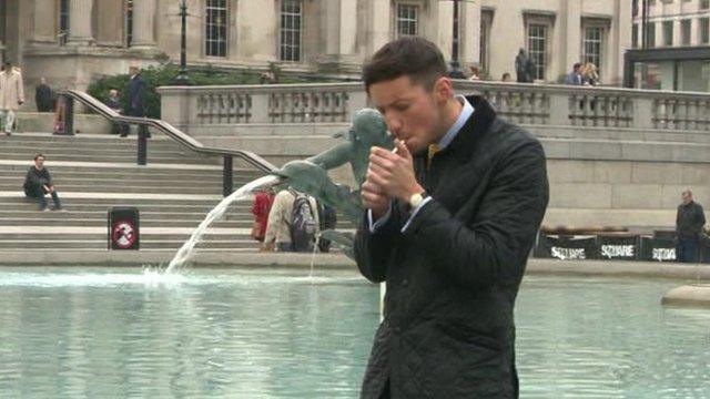 Man lighting cigarette in Trafalgar Square