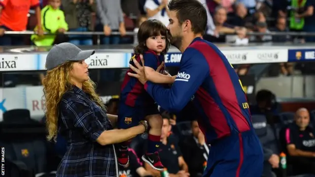 Gerard Pique of FC Barcelona passes his son Milan to his wife Shakira