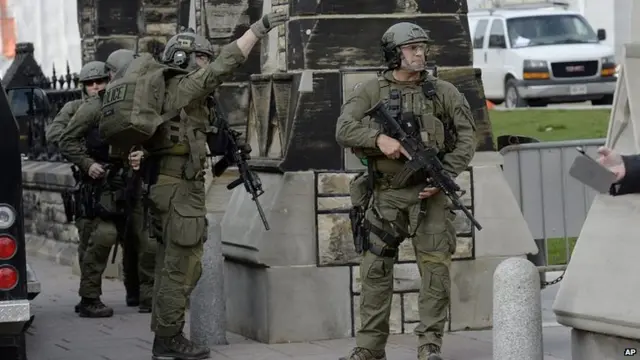 Royal Canadian Mounted Police intervention team walks past a gate on Parliament Hill. 22 Oct 2014