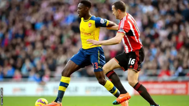 Arsenal striker Danny Welbeck battles for the ball with John O'Shea of Sunderland