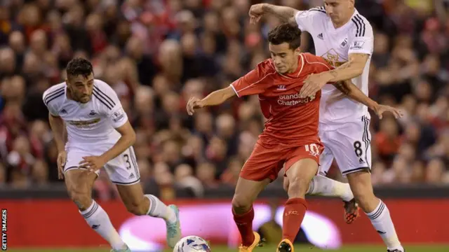 Liverpool's Phillipe Coutinho is marshalled by Swansea's Jonjo Shelvey