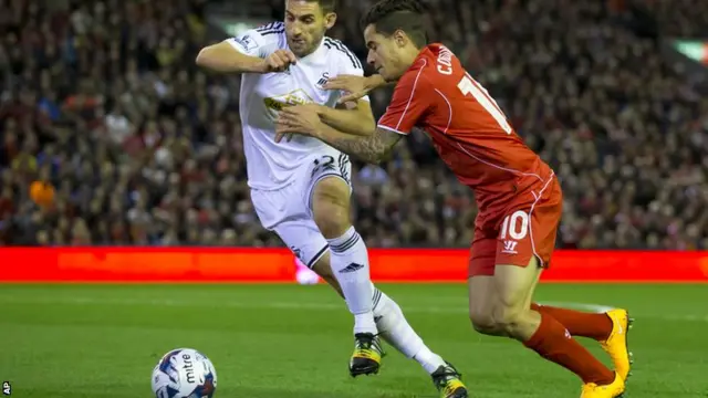 Liverpool's Phillipe Coutinho is tackled by Swansea's Angel Rangel