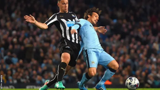 Newcastle United defender Ryan Taylor tackles Manchester City's David Silva