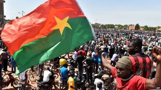 People celebrate at the Place de la Nation in the capital Ouagadougou, after Burkina Faso's embattled President Blaise Compaore announced earlier on 31 October 2014