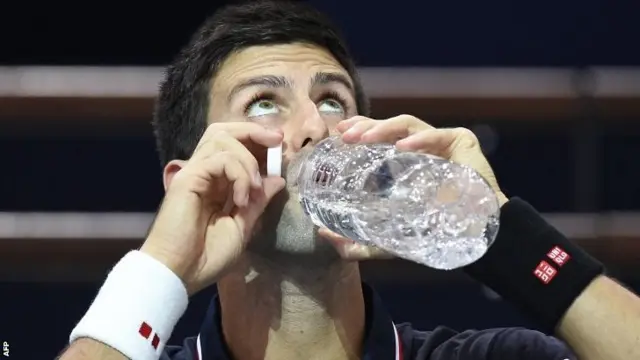 Novak Djokovic takes a drink