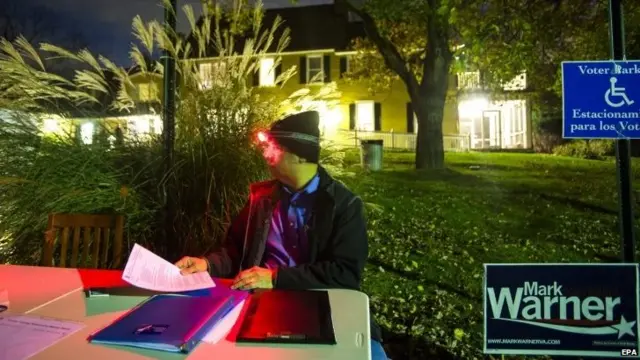 Luis Parava with the Fairfax County Democrats mans an information table in the pre-dawn hours as Virginia residents prepare to vote in the 2014 US midterm elections at a historic property called the Hunter House at Nottoway Park in Vienna, Virginia, USA, 4 November 2014