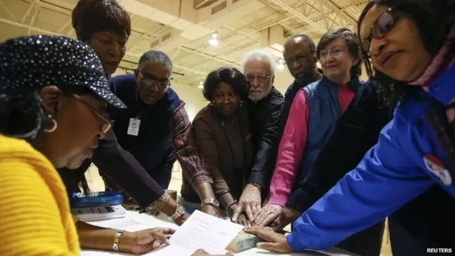 Head precinct judge Deloris Reid-Smith (left) reads the voters oath to poll workers before opening the polls at the Grove Presbyterian Church in Charlotte, North Carolina November 4, 2014