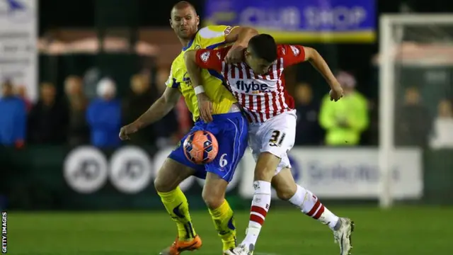 Craig Robinson and Graham Cummins challenge for the ball