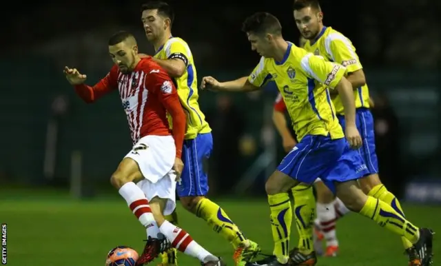 Liam Sercombe is challenged for possession