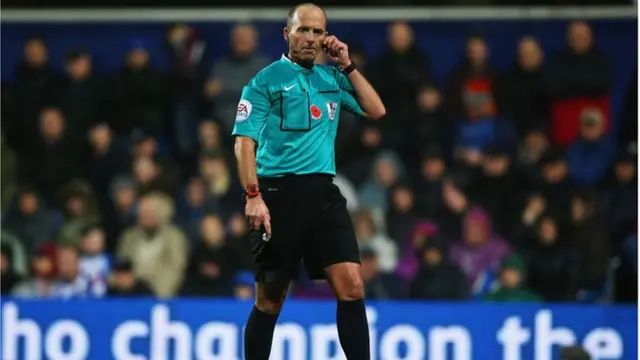 Mike Dean looks on during the QPR v Manchester City game