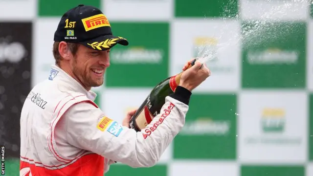 Jenson Button of Great Britain and McLaren celebrates on the podium after winning the Brazilian Formula One Grand Prix in 2012.