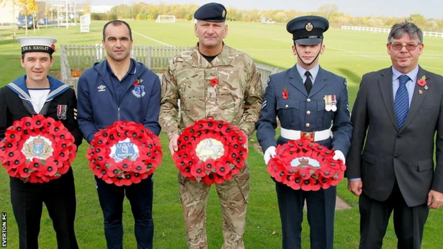 Everton staff pose with poppy reefs