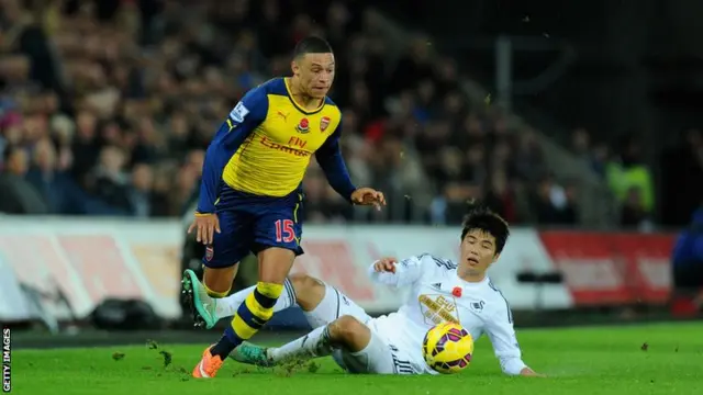 Alex -xlade-Chamberlain is challenged by Ki Sung-yueng