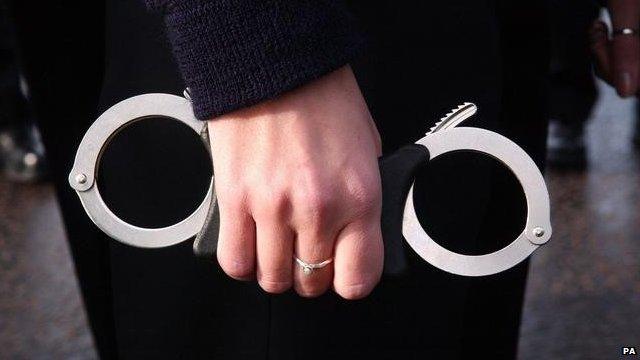 Hand holding handcuffs