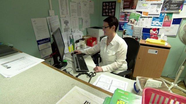 GP surgery receptionist at her desk