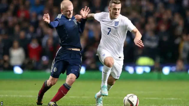 England's Jack Wilshere holds off Steven Naismith