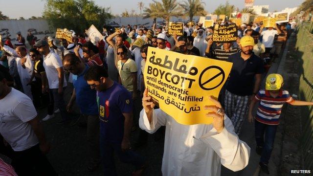 Protesters hold signs as they march during a rally organised by Bahrain's main opposition party Al Wefaq in Budaiya, west of Manama