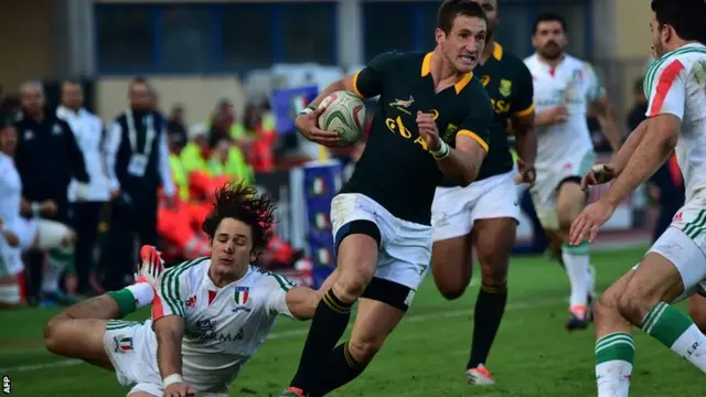 South Africa"s fly half Johannes Goosen runs with the ball past by Italys centre Michele Campagnaro