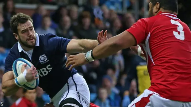 Scotlands centre Alex Dunbar hands off Tongas prop Paea Faanunu