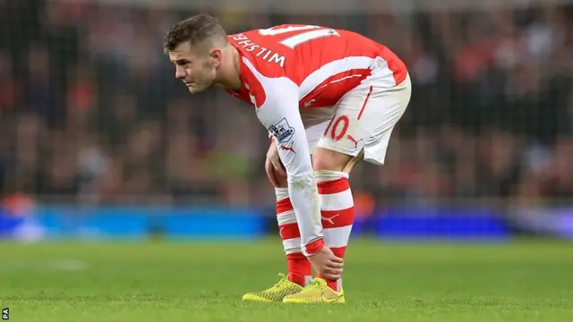 Arsenal's Jack Wilshere clutches his ankle