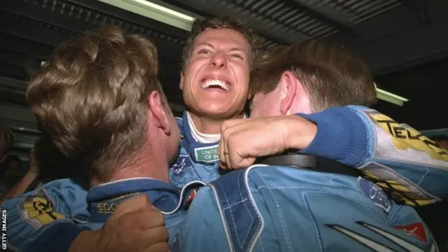 13 Nov 1994: Benetton Ford driver Michael Schumacher of Germany hugs two team mechanics in delight for becoming World Champion Driver after the Australian Grand Prix