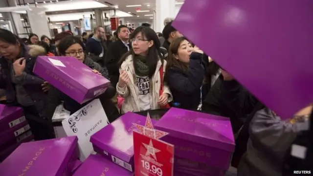 People sort through boxes of shoes in Macy"s