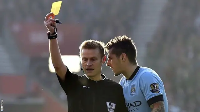 Sergio Aguero recieves a yellow card