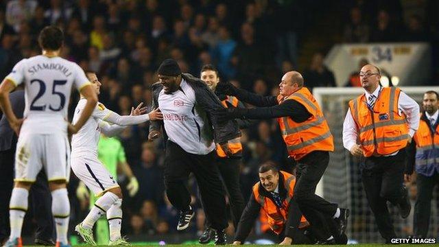 A pitch invader is apprehended at White Hart Lane