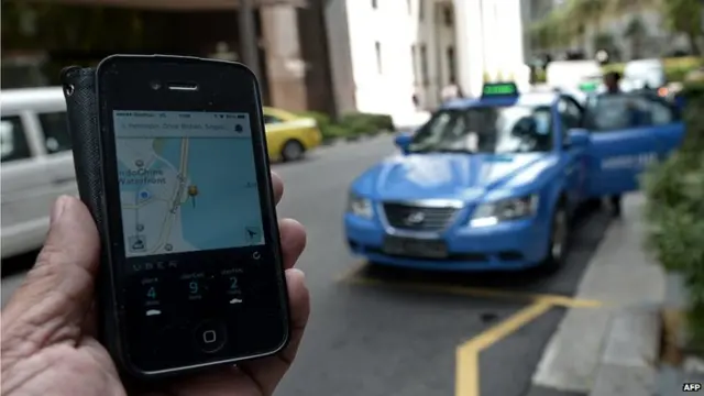 A smartphone displaying the Uber app of the timing and availability of taxis within the area at Raffles place financial district in Singapore