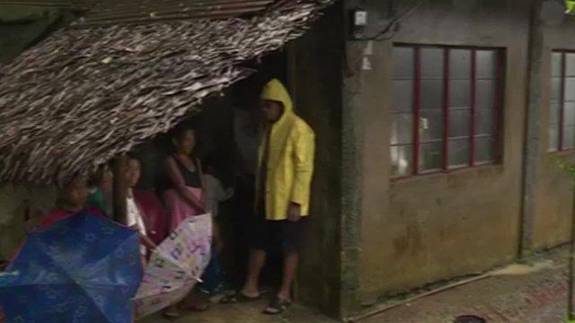 Family sheltering under thatched roof