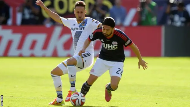 New England Revolution midfielder Lee Nguyen (right) battles for the ball with Los Angeles Galaxy midfielder Marcelo Sarvas