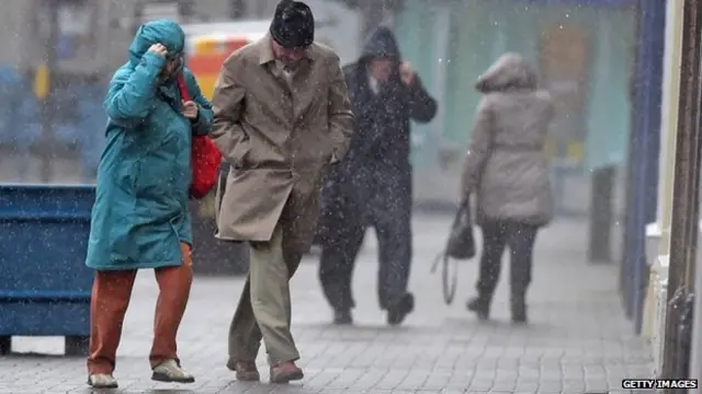 Members of the public struggle with the weather in Troon