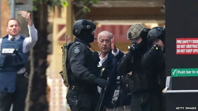 A hostage runs to safety outside the Lindt Cafe, Martin Place on 15 December 2014 in Sydney, Australia