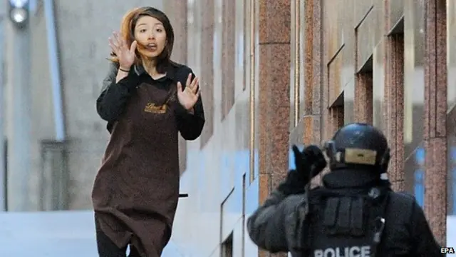 A female employee manages to escape from the Lindt Chocolate cafe in Martin Place, Sydney, Dec. 15, 2014 after a gunman took dozens of people hostage.