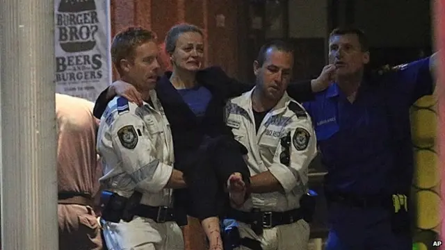 Injured woman is carried away by an ambulance crew from the scene of the attack